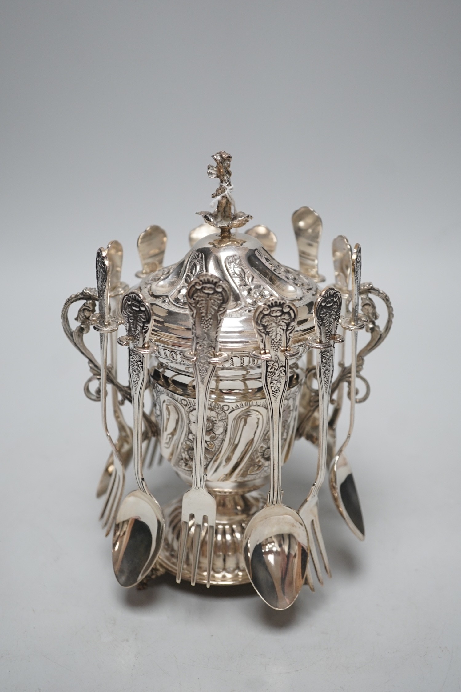 A modern Greek 925 dessert set, comprising an embossed pedestal cup and cover with cherub finial and six hanging spoons and six forks, height 21.6cm, with box
